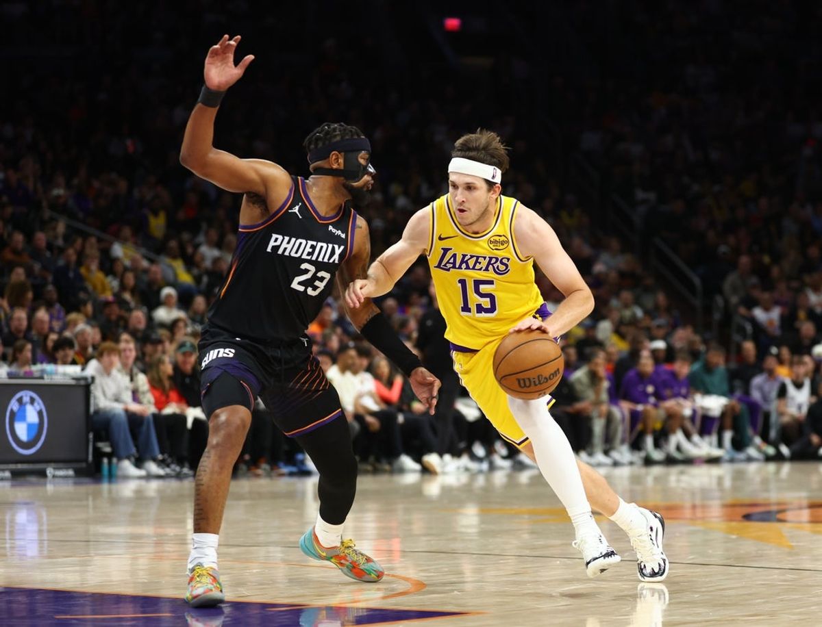 Dec 23, 2025; Phoenix, Arizona, USA; Los Angeles Lakers guard Austin Reaves (15) against Phoenix Suns guard Jordan Goodwin (23) in the second half at Mortgage Matchup Center. Mandatory Credit: Mark J. Rebilas-Imagn Images