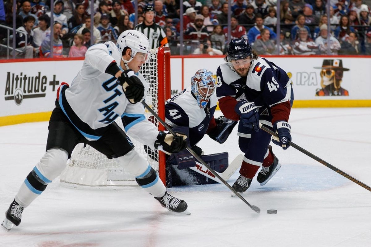 Dec 23, 2025; Denver, Colorado, USA; Utah Mammoth right wing JJ Peterka (77) controls the puck against Colorado Avalanche defenseman Samuel Girard (49) and goaltender Scott Wedgewood (41) in the third period at Ball Arena. Mandatory Credit: Isaiah J. Downing-Imagn Images