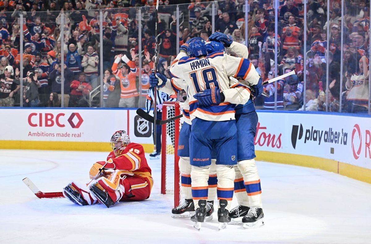 Dec 23, 2025; Edmonton, Alberta, CAN; Oilers center Connor McDavid (97), center Leon Draisaitl (29), and left winger Zach Hyman (18) celebrate a goal on Calgary Flames goalie Dustin Wolf (32) during the third period at Rogers Place. Mandatory Credit: Walter Tychnowicz-Imagn Images