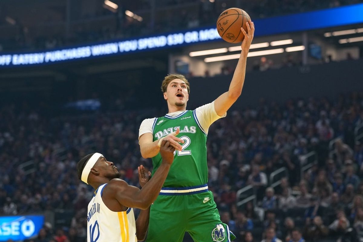 Dec 25, 2025; San Francisco, California, USA; Dallas Mavericks forward Cooper Flagg (center) shoots against Golden State Warriors forward Jimmy Butler III (10) during the first quarter at Chase Center. Mandatory Credit: Darren Yamashita-Imagn Images