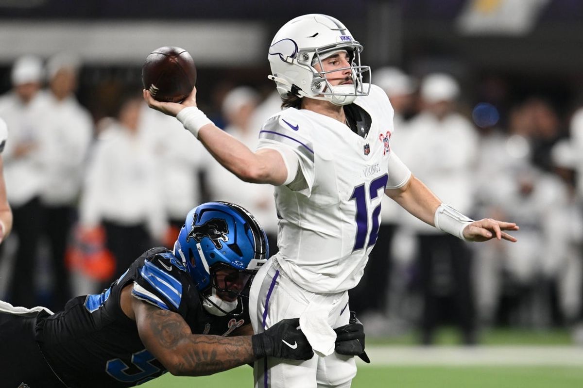 Dec 25, 2025; Minneapolis, Minnesota, USA; Minnesota Vikings quarterback Max Brosmer (12) passes the ball under pressure from Detroit Lions linebacker Derrick Barnes (55) in the second quarter at U.S. Bank Stadium. Mandatory Credit: Jeffrey Becker-Imagn Images