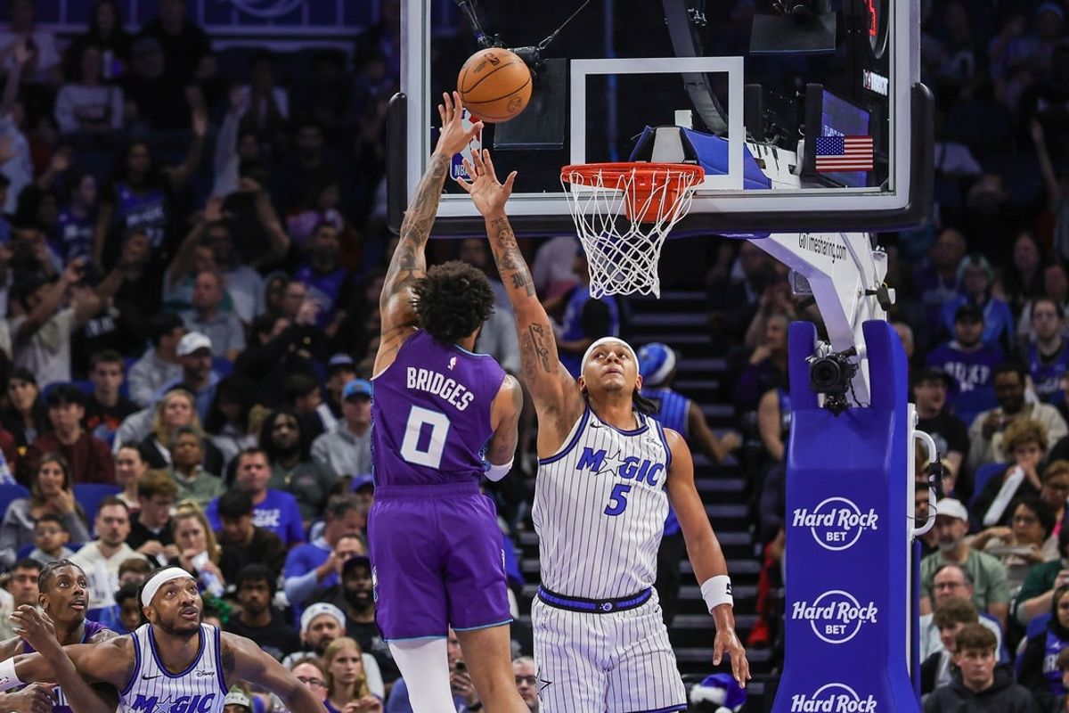 Dec 26, 2025; Orlando, Florida, USA; Charlotte Hornets forward Miles Bridges (0) shoots against Orlando Magic forward Paolo Banchero (5) during the first quarter at Kia Center. Mandatory Credit: Mike Watters-Imagn Images
