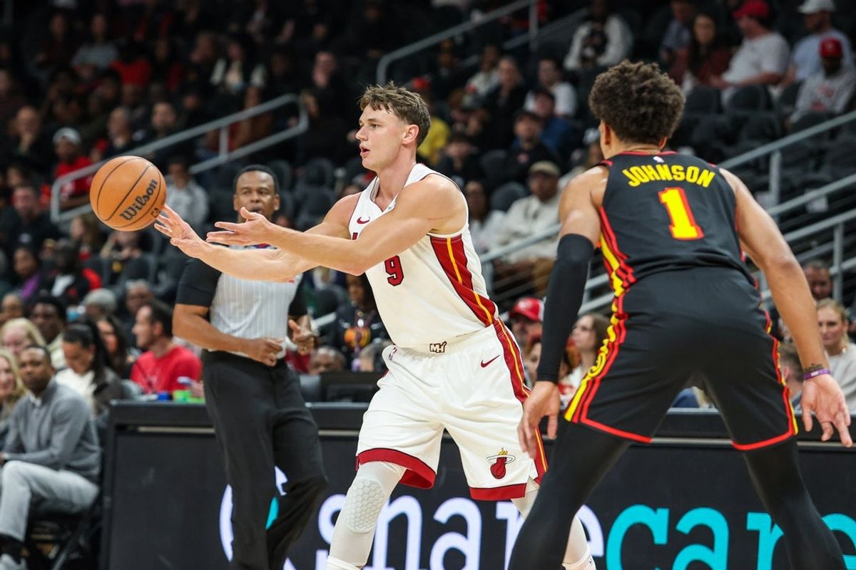 Dec 26, 2025; Atlanta, Georgia, USA; Miami Heat guard Pelle Larsson (9) makes a pass against Atlanta Hawks forward Jalen Johnson (1) during the first quarter at State Farm Arena. Mandatory Credit: Jordan Godfree-Imagn Images