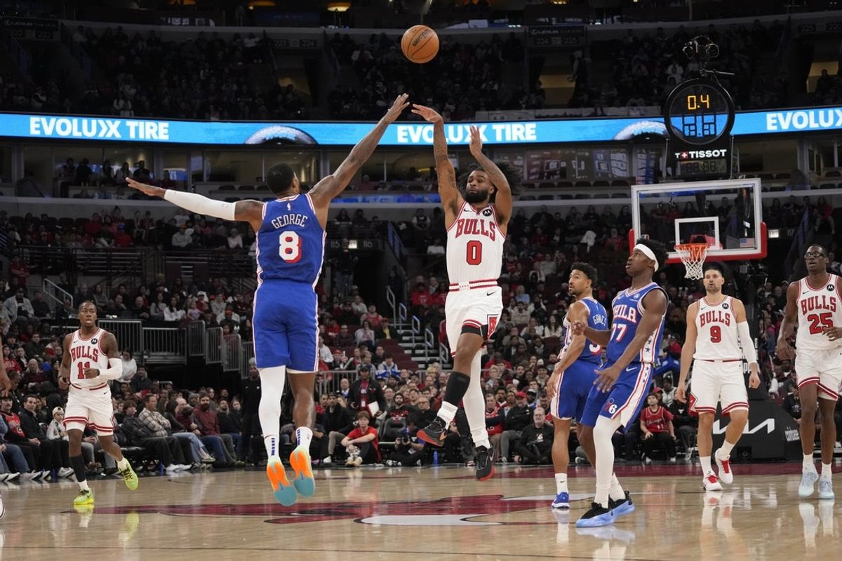 Dec 26, 2025; Chicago, Illinois, USA; Chicago Bulls guard Coby White (0) shoots the ball over Philadelphia 76ers forward Paul George (8) during the first half at United Center. Mandatory Credit: David Banks-Imagn Images