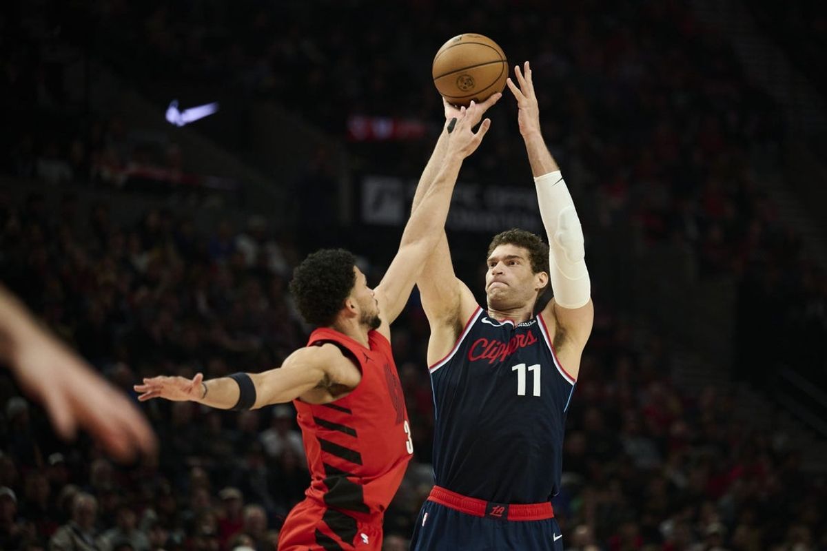 Dec 26, 2025; Portland, Oregon, USA; LA Clippers center Brook Lopez (11) shoots a three point basket during the first half against Portland Trail Blazers forward Toumani Camara (33) at Moda Center. Mandatory Credit: Troy Wayrynen-Imagn Images