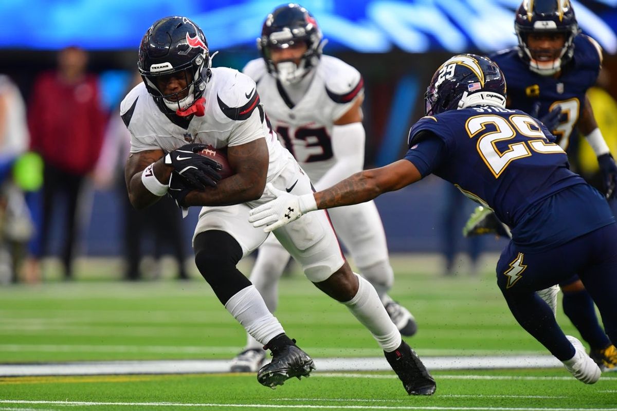 Dec 27, 2025; Inglewood, California, USA;  Houston Texans running back Woody Marks (27) carries the ball as Los Angeles Chargers cornerback Tarheeb Still (29) defends during the second half at SoFi Stadium. Mandatory Credit: Gary A. Vasquez-Imagn Images