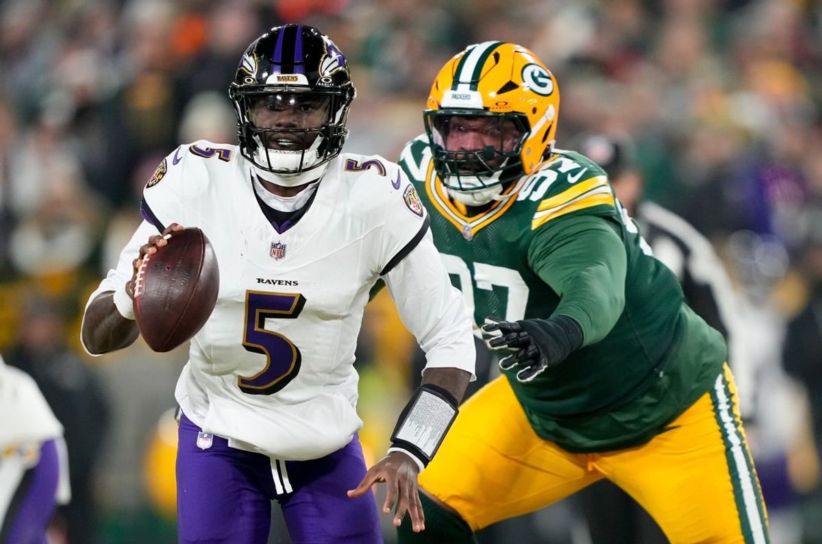 Dec 27, 2025; Green Bay, Wisconsin, USA; Baltimore Ravens quarterback Tyler Huntley (5) looks to throw a pass as Green Bay Packers defensive tackle Jordon Riley (97) defends during the first quarter at Lambeau Field. Mandatory Credit: Kayla Wolf-Imagn Images