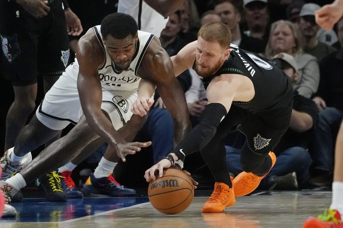 Dec 27, 2025; Minneapolis, Minnesota, USA; Brooklyn Nets center Day'Ron Sharpe (20) competes for the ball with Minnesota Timberwolves guard Donte DiVincenzo (0) in the second quarter at Target Center. Mandatory Credit: Bruce Kluckhohn-Imagn Images