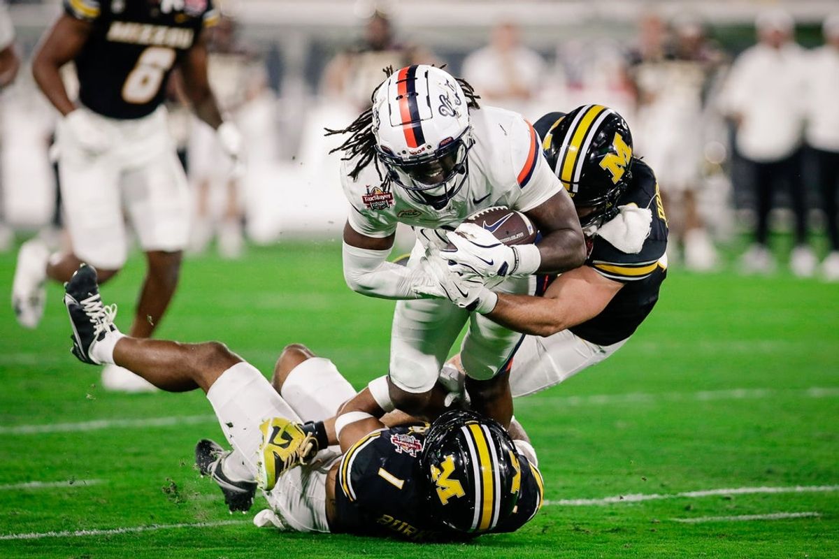Dec 27, 2025; Jacksonville, FL, USA; Virginia Cavaliers wide receiver Jahmal Edrine (7) is tackled after a catch against the Missouri Tigers during the second quarter at EverBank Stadium. Mandatory Credit: Travis Register-Imagn Images