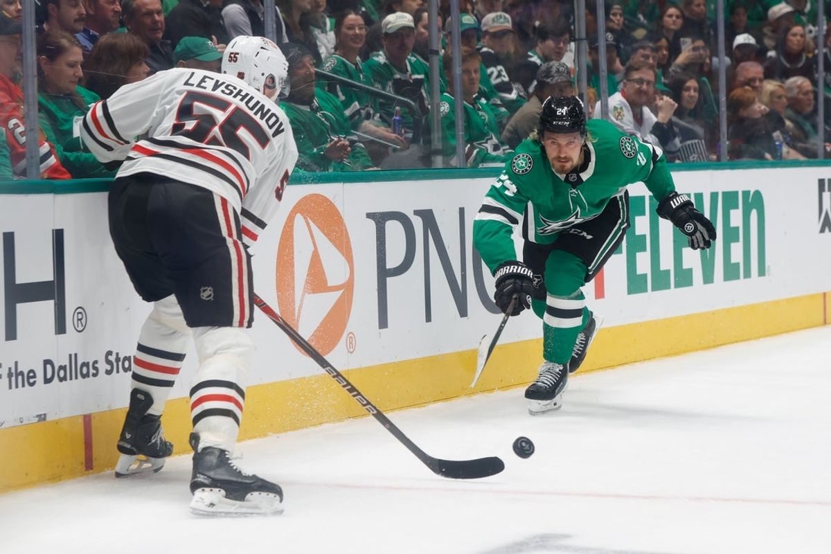 Dec 27, 2025; Dallas, Texas, USA;  Dallas Stars center Roope Hintz (24) and Chicago Blackhawks defenseman Artyom Levshunov (55) chase the puck during the second period at American Airlines Center. Mandatory Credit: Chris Jones-Imagn Images