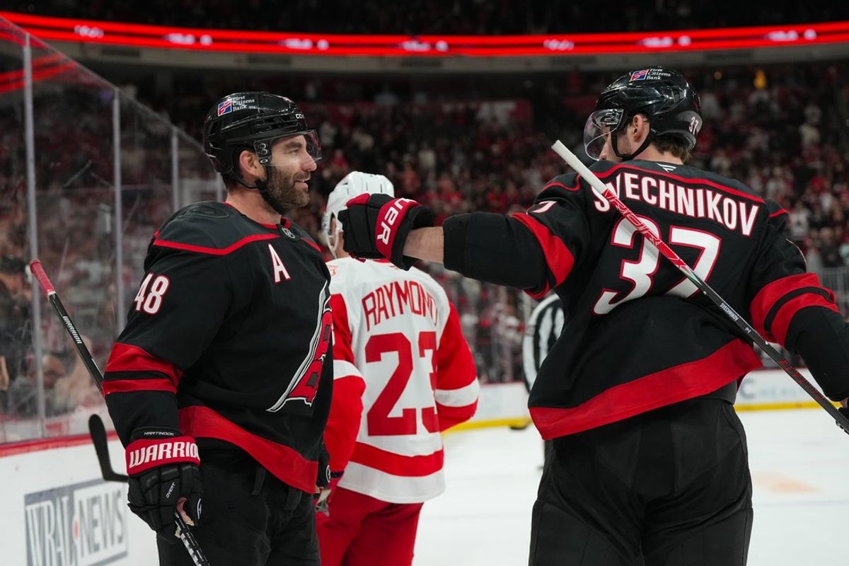 Dec 27, 2025; Raleigh, North Carolina, USA;  Carolina Hurricanes left wing Jordan Martinook (48) celebrates his empty net goal with right wing Andrei Svechnikov (37) against the Detroit Red Wings during the third period at Lenovo Center. Mandatory Credit: James Guillory-Imagn Images