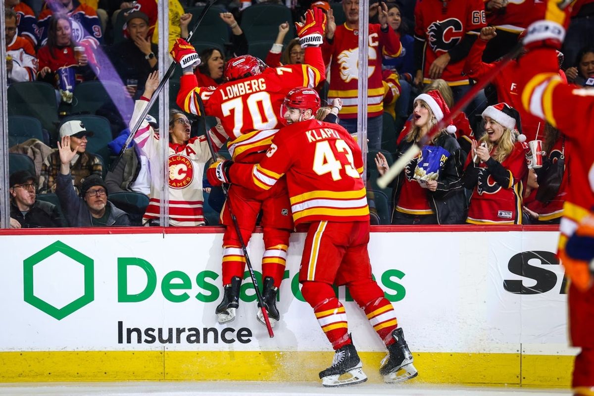Dec 27, 2025; Calgary, Alberta, CAN; Calgary Flames left wing Ryan Lomberg (70) celebrates his goal with right wing Adam Klapka (43) during the second period against the Edmonton Oilers at Scotiabank Saddledome. Mandatory Credit: Sergei Belski-Imagn Images
