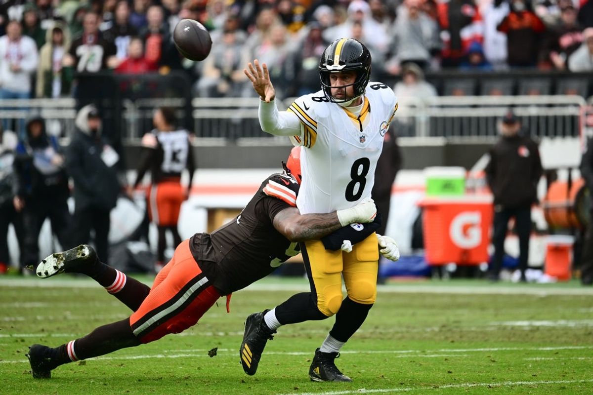 Dec 28, 2025; Cleveland, Ohio, USA; Pittsburgh Steelers quarterback Aaron Rodgers (8) tosses the ball while tackled by Cleveland Browns defensive end Alex Wright (91) in the second quarter at Huntington Bank Field. Mandatory Credit: Ken Blaze-Imagn Images