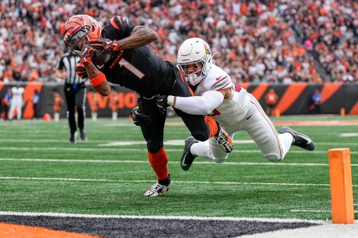 Cincinnati Bengals wide receiver Ja'Marr Chase (1) breaks a tackle from Arizona Cardinals linebacker Cody Simon (50) as he dives into the end zone for a touchdown in the first quarter of the NFL Week 17 game between the Cincinnati Bengals and the Arizona Cardinals at Paycor Stadium in Downtown Cincinnati on Sunday, Dec. 28, 2025. The Bengals led 23-7 at halftime.