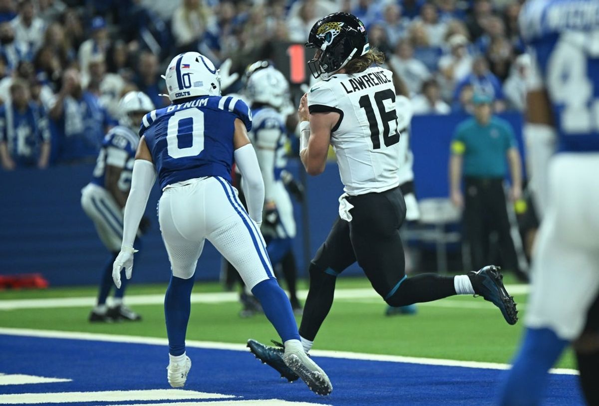 Dec 28, 2025; Indianapolis, Indiana, USA; Jacksonville Jaguars quarterback Trevor Lawrence (16) scores a touchdown during the second half against the Indianapolis Colts at Lucas Oil Stadium. Mandatory Credit: Robert Goddin-Imagn Images
