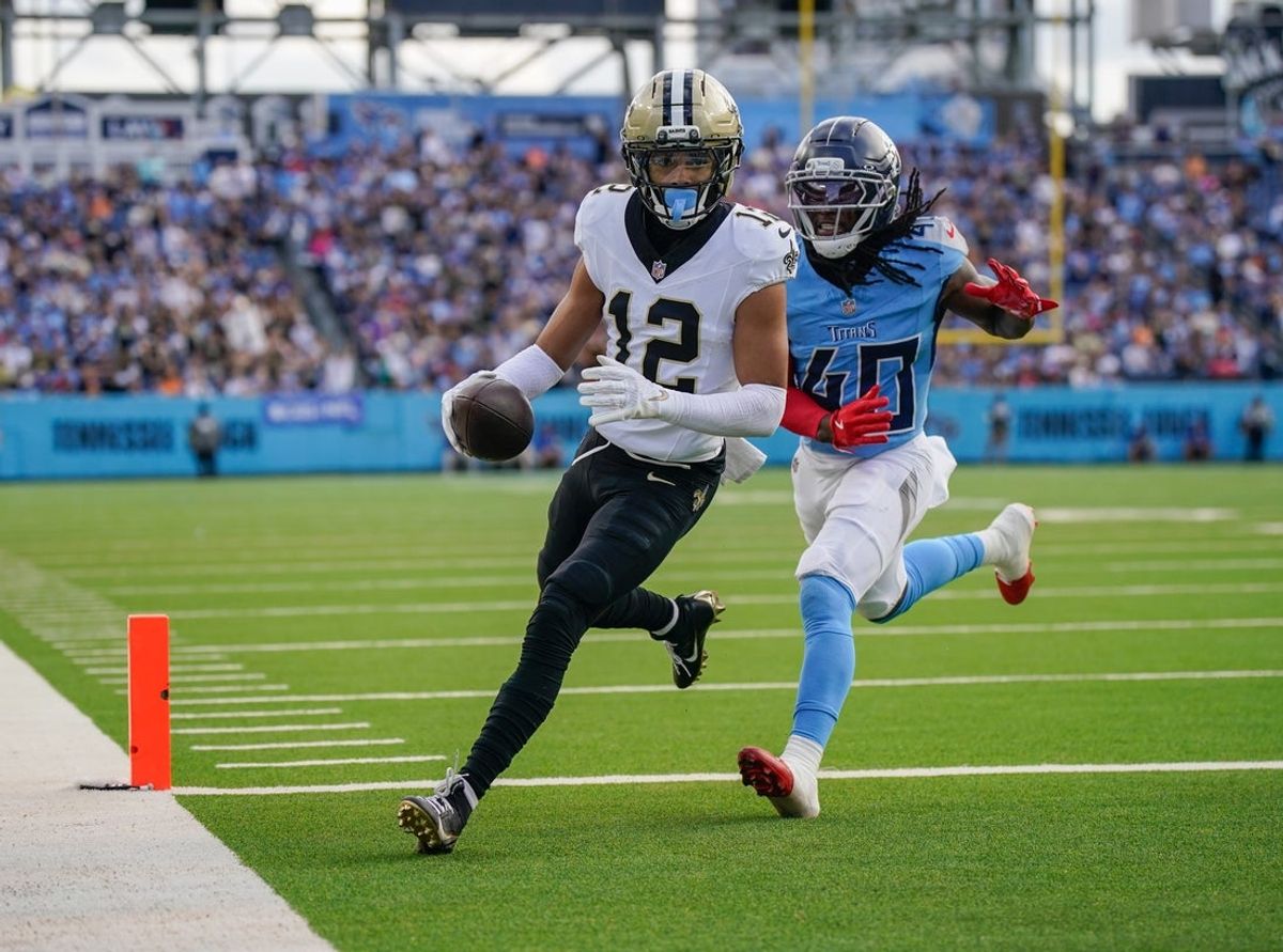 New Orleans Saints wide receiver Chris Olave (12) runs in a touchdown in front of Tennessee Titans cornerback Kemon Hall (40) during the third quarter at Nissan Stadium in Nashville, Tenn., Sunday, Dec. 28, 2025.