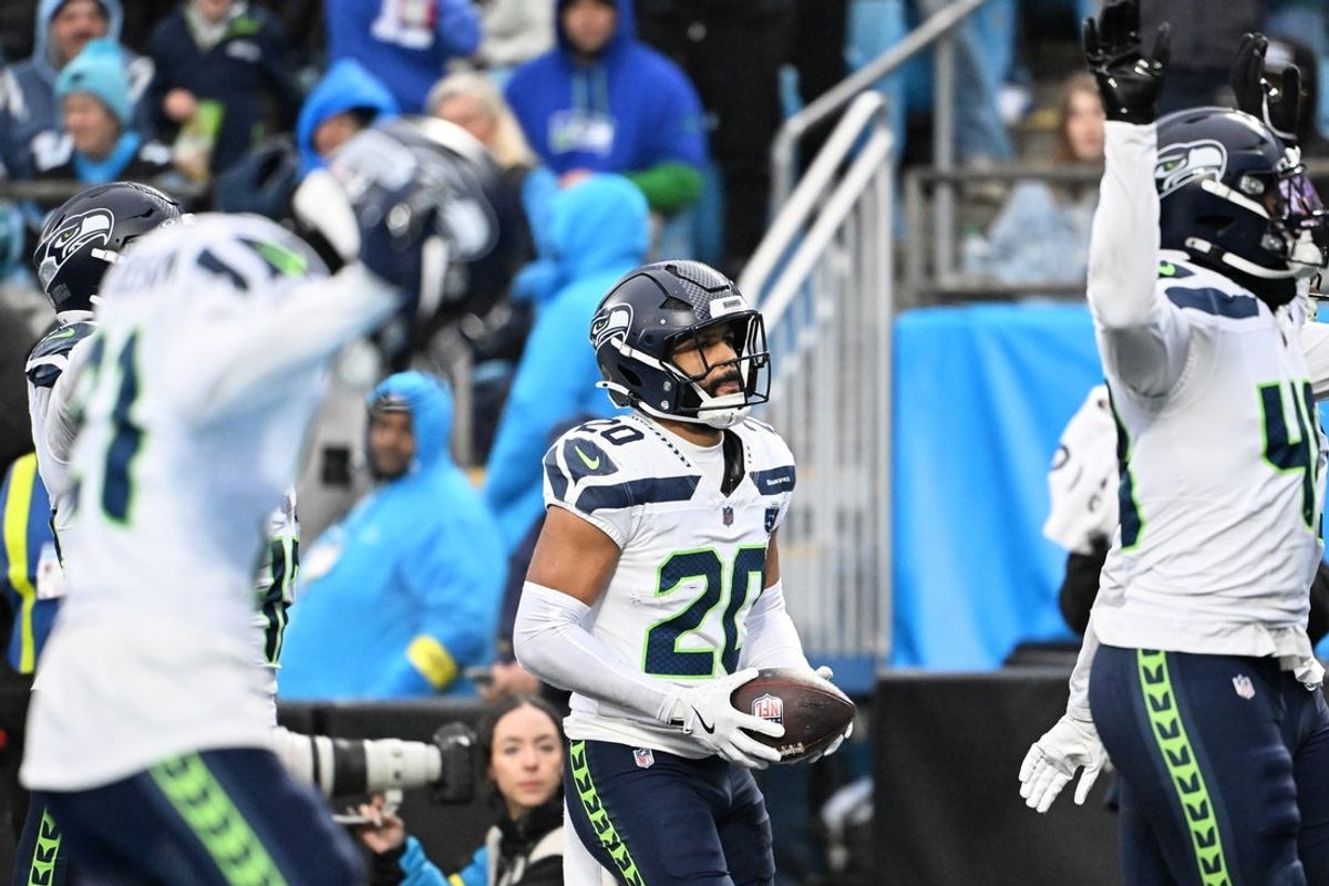 Dec 28, 2025; Charlotte, North Carolina, USA; Seattle Seahawks safety Julian Love (20) reacts after intercepting a pass intended for wide receiver Tetairoa McMillan (not pictured) during the third quarter at Bank of America Stadium. Mandatory Credit: Bob Donnan-Imagn Images