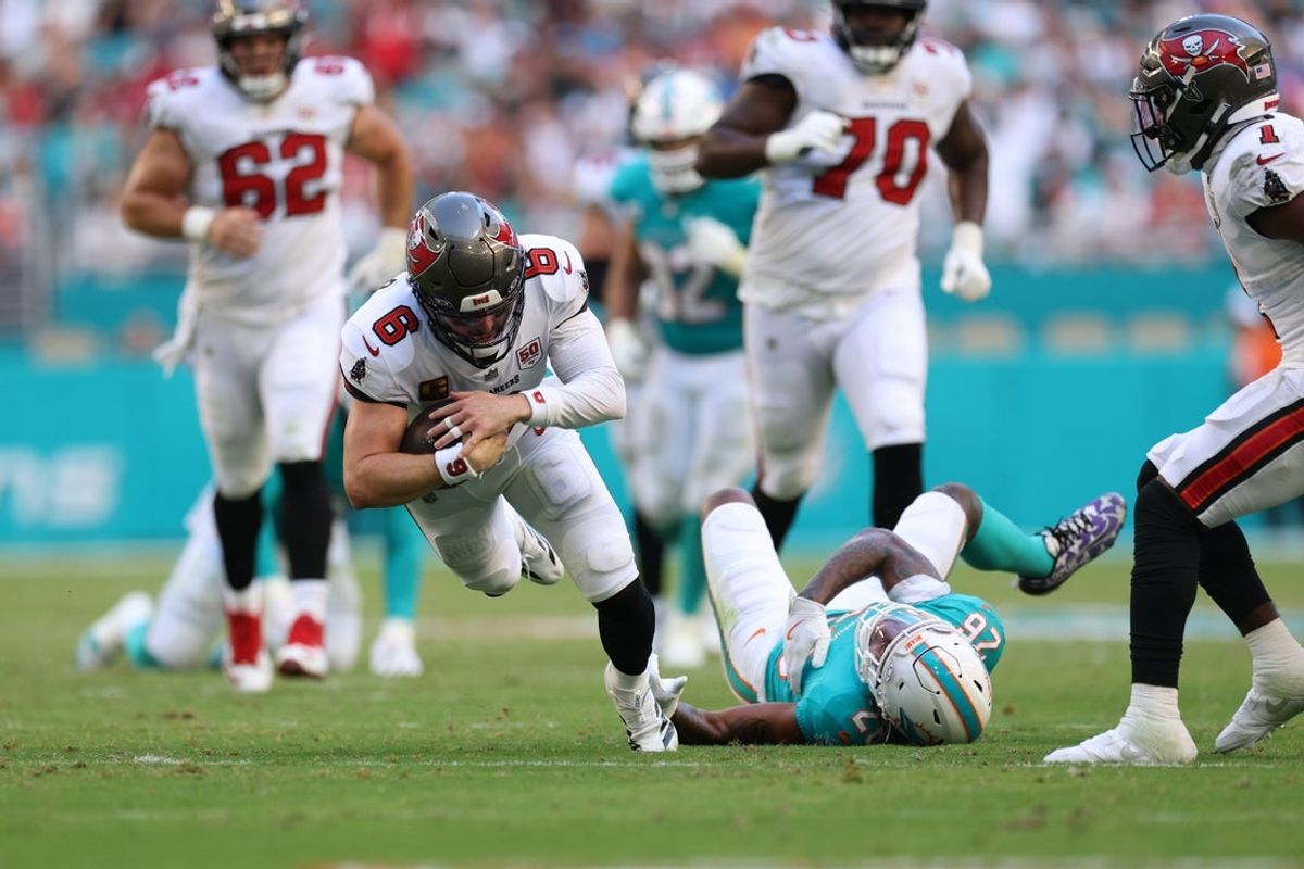 Dec 28, 2025; Miami Gardens, Florida, USA; Tampa Bay Buccaneers quarterback Baker Mayfield (6) dives for a gain past Miami Dolphins cornerback Rasul Douglas (26) during the fourth quarter at Hard Rock Stadium. Mandatory Credit: Nathan Ray Seebeck-Imagn Images