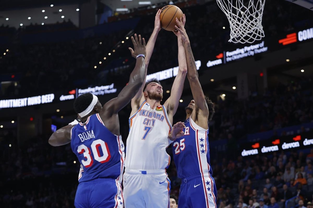 Dec 28, 2025; Oklahoma City, Oklahoma, USA; Oklahoma City Thunder center Chet Holmgren (7) goes up for a basket between Philadelphia 76ers forward Dominick Barlow (25) and center Adem Bona (30) during the second half at Paycom Center. Mandatory Credit: Alonzo Adams-Imagn Images