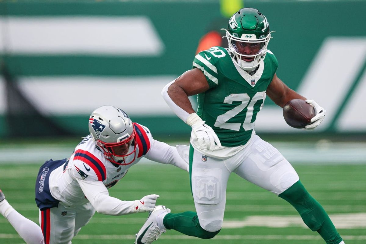 Dec 28, 2025; East Rutherford, New Jersey, USA; New York Jets running back Breece Hall (20) carries the ball as New England Patriots linebacker K'Lavon Chaisson (44) pursues at MetLife Stadium. Mandatory Credit: Vincent Carchietta-Imagn Images