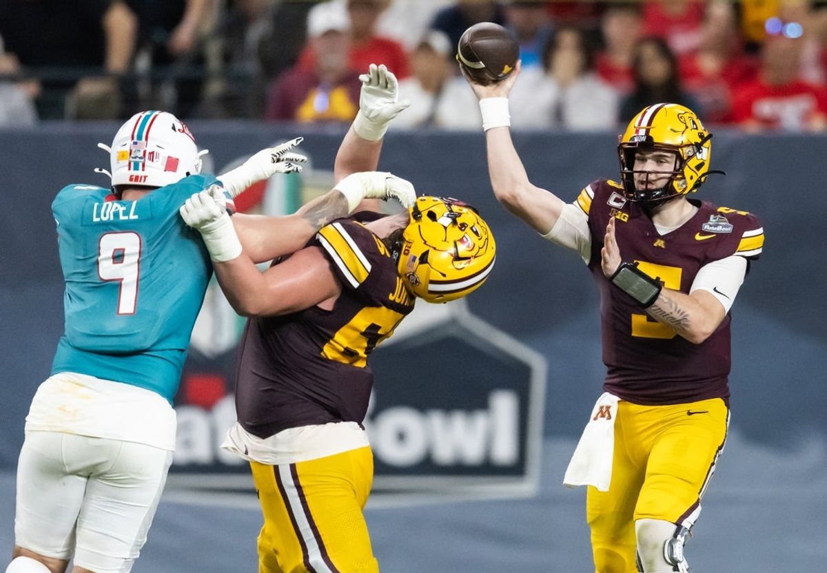 Dec 26, 2025; Phoenix, AZ, USA; Minnesota Golden Gophers quarterback Drake Lindsey (5) throws a pass as offensive lineman Greg Johnson (65) blocks New Mexico Lobos defensive end Gabriel Lopez (9) during the Rate Bowl at Chase Field. Mandatory Credit: Mark J. Rebilas-Imagn Images