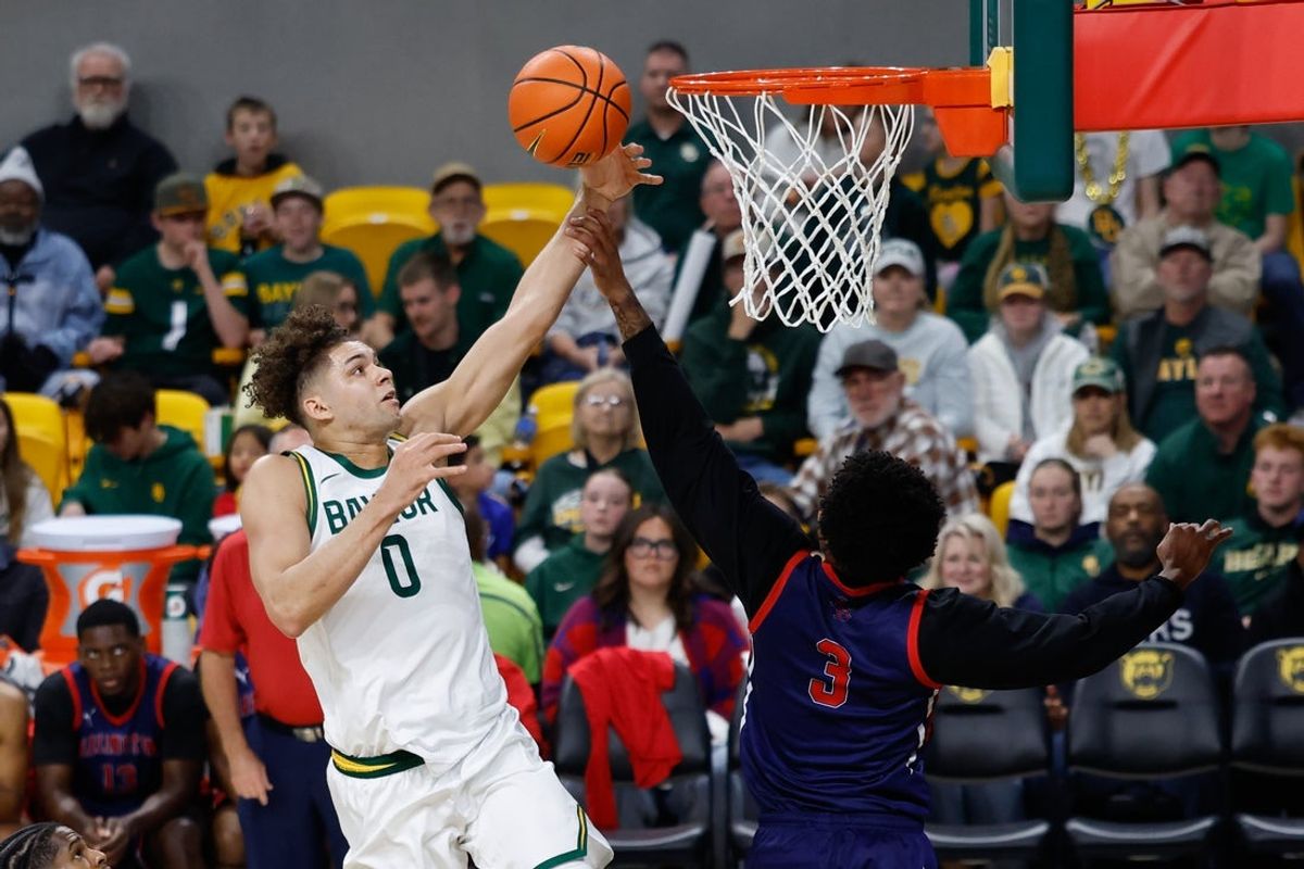 Dec 29, 2025; Waco, Texas, USA; Baylor Bears guard Dan Skillings Jr. (0) is fouled by Arlington Baptist Patriots guard Bryce Archie (3) during the first half at Paul and Alejandra Foster Pavilion. Mandatory Credit: Chris Jones-Imagn Images