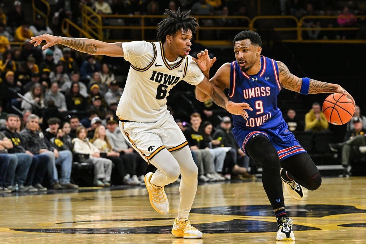 Dec 29, 2025; Iowa City, Iowa, USA; UMass Lowell River Hawks guard Angel Montas Jr. (9) controls the ball as Iowa Hawkeyes guard Tavion Banks (6) defends during the first half at Carver-Hawkeye Arena. Mandatory Credit: Jeffrey Becker-Imagn Images