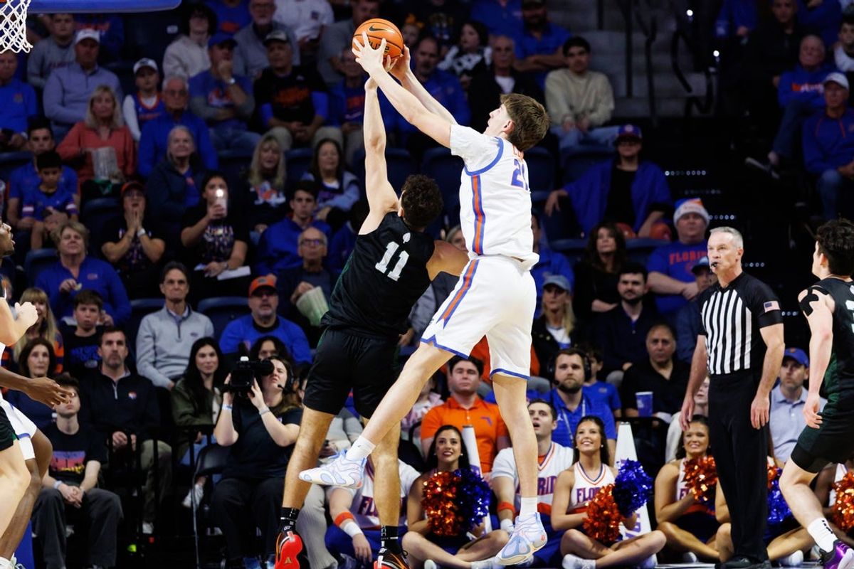 Dec 29, 2025; Gainesville, Florida, USA; Florida Gators forward Alex Condon (21) grabs a rebound over Dartmouth Big Green guard Cameron Hiatt (11) during the first half at Exactech Arena at the Stephen C. O'Connell Center. Mandatory Credit: Matt Pendleton-Imagn Images