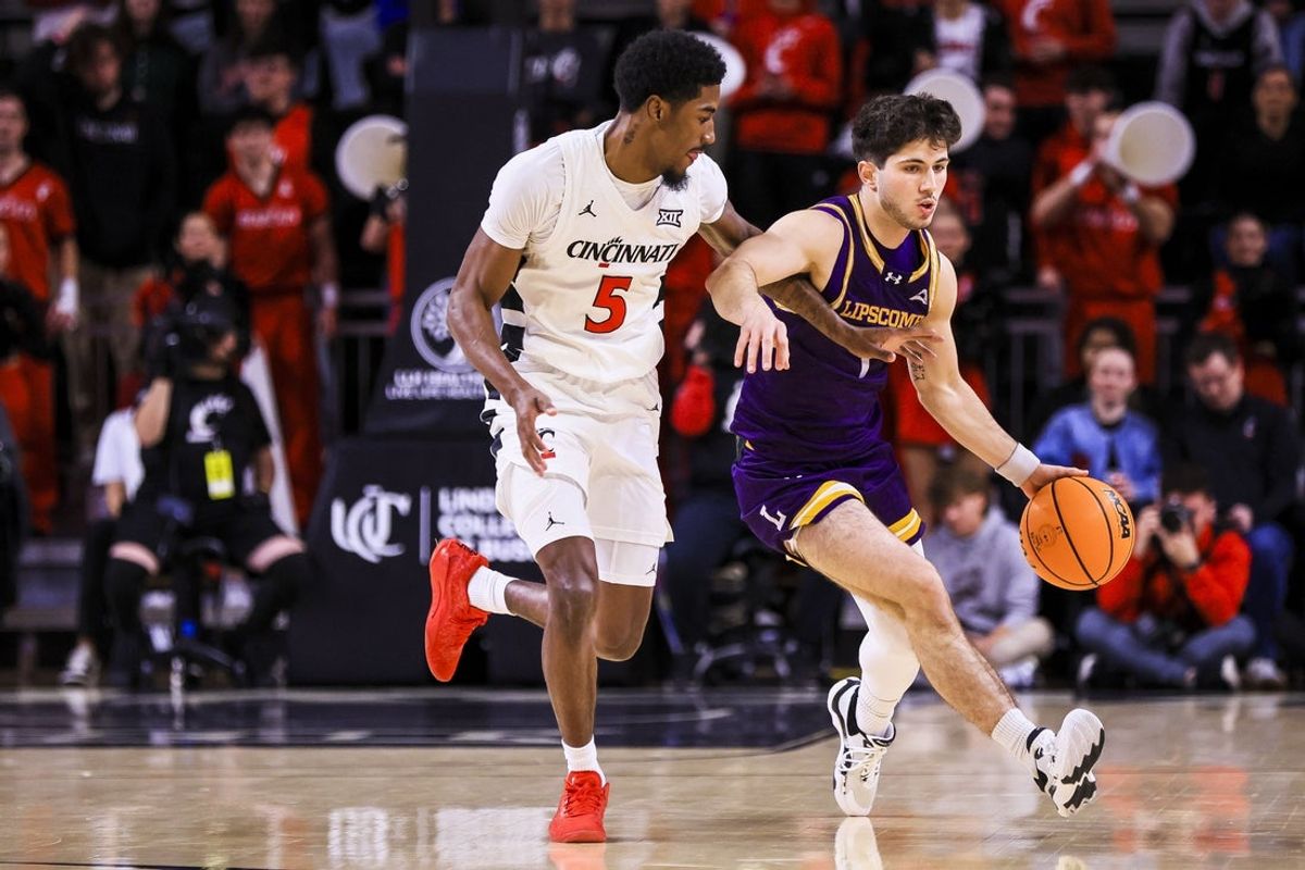 Dec 29, 2025; Cincinnati, Ohio, USA; Lipscomb Bisons guard Mateo Esmeraldo (1) dribbles against Cincinnati Bearcats guard Sencire Harris (5) in the first half at Fifth Third Arena. Mandatory Credit: Katie Stratman-Imagn Images
