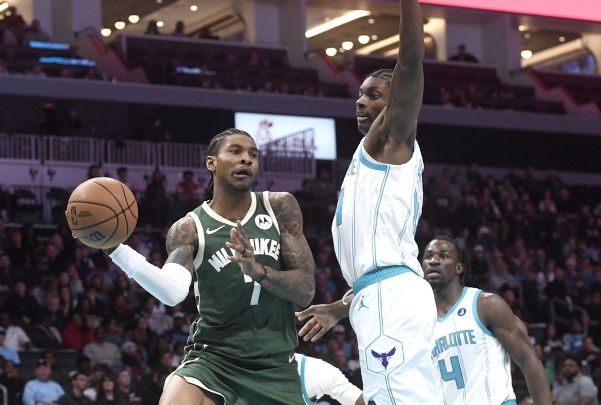 Dec 29, 2025; Charlotte, North Carolina, USA;  Milwaukee Bucks guard Kevin Porter Jr. (7) looks to pass against Charlotte Hornets forward center Moussa Diabate (14) during the first half at the Spectrum Center. Mandatory Credit: Sam Sharpe-Imagn Images