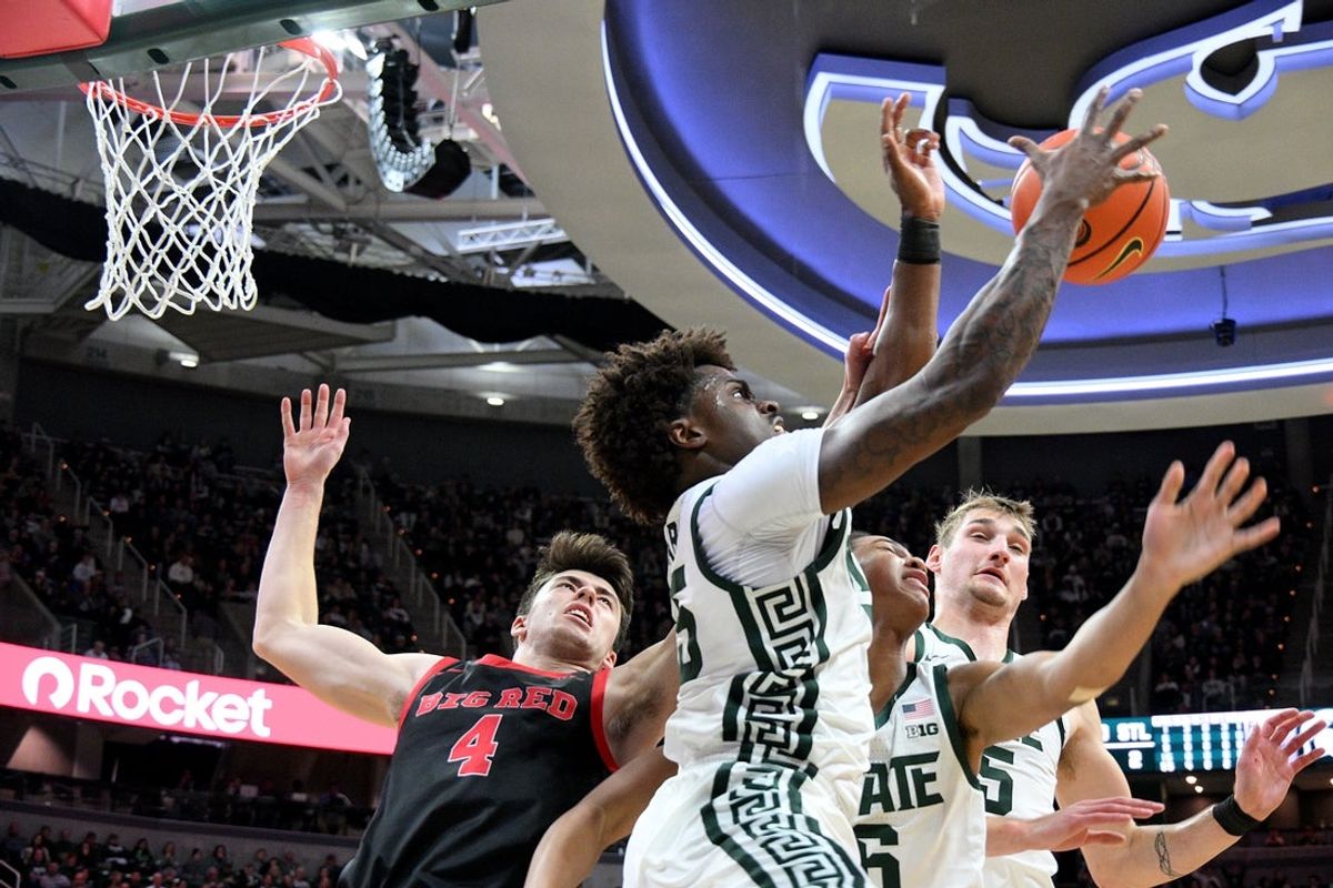 Dec 29, 2025; East Lansing, Michigan, USA;  Michigan State Spartans forward Coen Carr (55) takes a rebound away from Cornell Big Red forward Gioacchino Panzini (4) during the first half at Jack Breslin Student Events Center. Mandatory Credit: Dale Young-Imagn Images