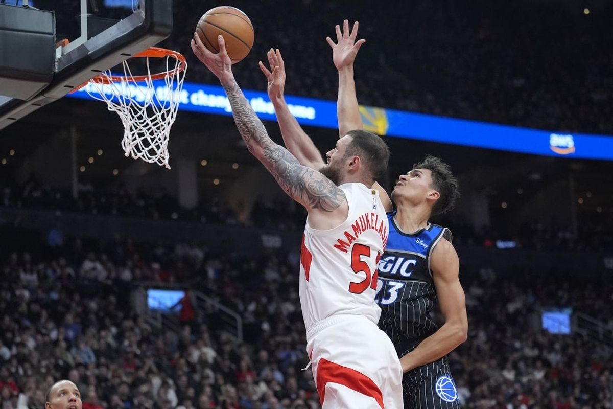 Dec 29, 2025; Toronto, Ontario, CAN; Toronto Raptors forward Sandro Mamukelashvili (54) goes up to make a basket against Orlando Magic forward Tristan da Silva (23)  during the first half at Scotiabank Arena. Mandatory Credit: John E. Sokolowski-Imagn Images