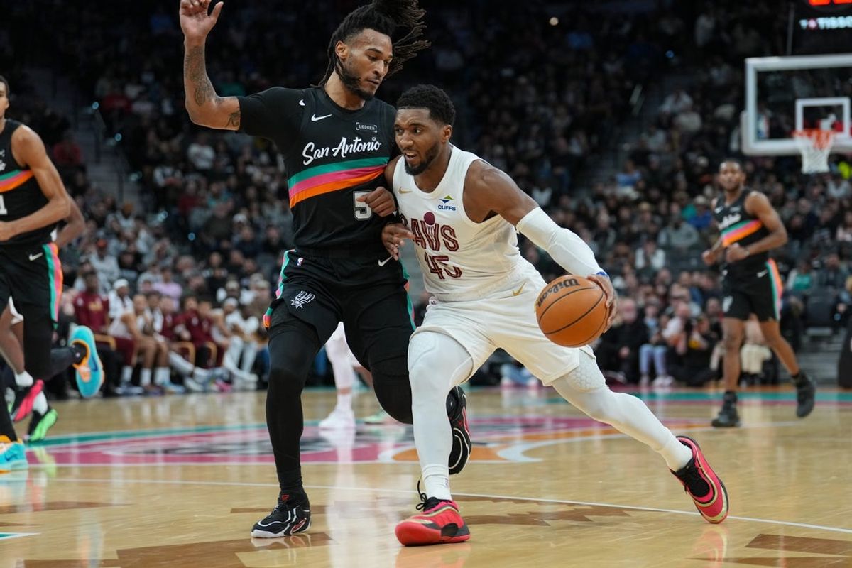 Dec 29, 2025; San Antonio, Texas, USA;  Cleveland Cavaliers guard Donovan Mitchell (45) dribbles against San Antonio Spurs guard Stephon Castle (5) in the first half at Frost Bank Center. Mandatory Credit: Daniel Dunn-Imagn Images