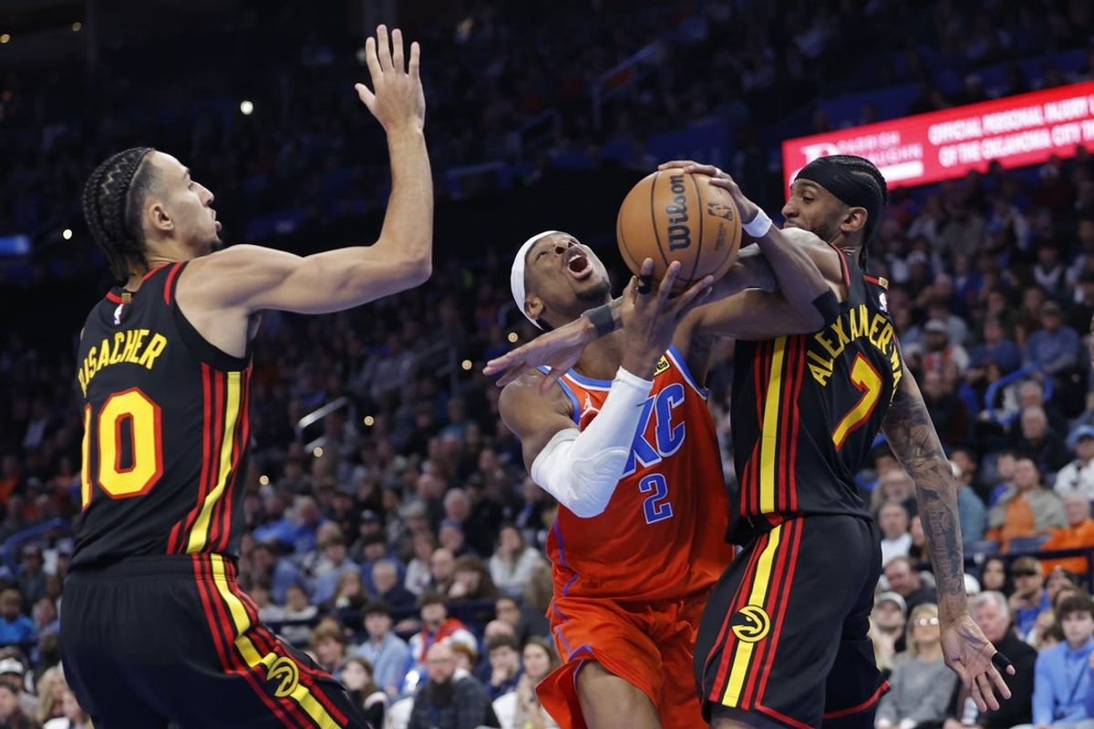 Dec 29, 2025; Oklahoma City, Oklahoma, USA; Oklahoma City Thunder guard Shai Gilgeous-Alexander (2) is fouled by Atlanta Hawks guard Nickeil Alexander-Walker (7) during a drive to the basket in the second half at Paycom Center. Mandatory Credit: Alonzo Adams-Imagn Images