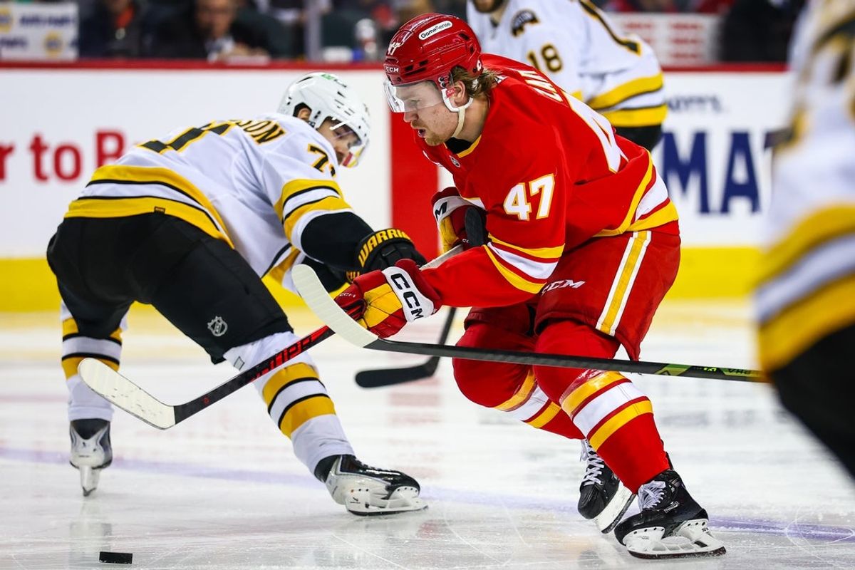 Dec 29, 2025; Calgary, Alberta, CAN; Calgary Flames center Connor Zary (47) controls the puck against the Boston Bruins during the second period at Scotiabank Saddledome. Mandatory Credit: Sergei Belski-Imagn Images