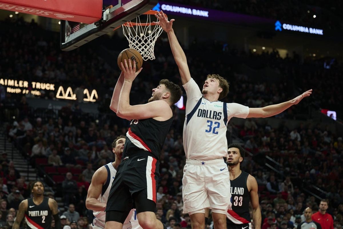 Dec 29, 2025; Portland, Oregon, USA; Portland Trail Blazers center Donovan Clingan (23) scores a basket during the first half against Dallas Mavericks forward Cooper Flagg (32) at Moda Center. Mandatory Credit: Troy Wayrynen-Imagn Images