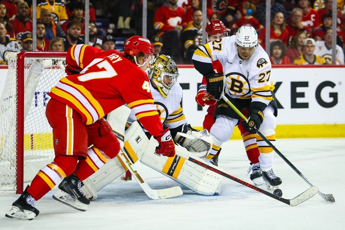 Dec 29, 2025; Calgary, Alberta, CAN; Calgary Flames center Connor Zary (47) scores a goal against Boston Bruins goaltender Jeremy Swayman (1) during the overtime period at Scotiabank Saddledome. Mandatory Credit: Sergei Belski-Imagn Images