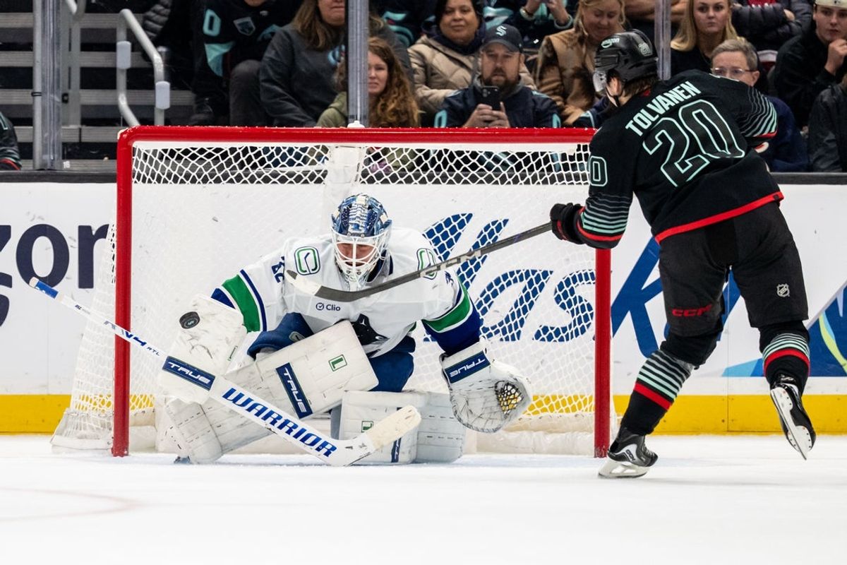 Dec 29, 2025; Seattle, Washington, USA; Vancouver Canucks goalie Kevin Lankinen (32) stops a shot by Seattle Kraken forward Eeli Tolvanen (20) during a shoot out at Climate Pledge Arena. Mandatory Credit: Stephen Brashear-Imagn Images