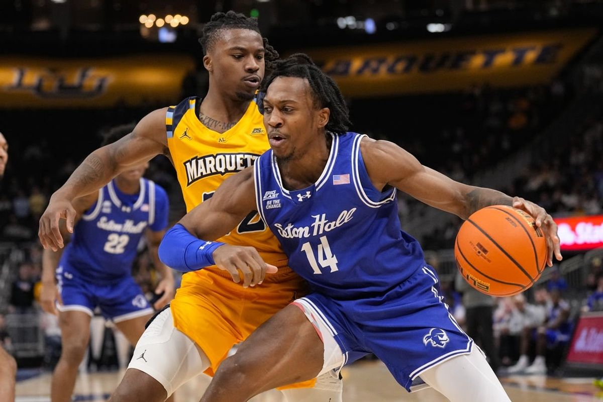 Dec 30, 2025; Milwaukee, Wisconsin, USA;  Seton Hall Pirates guard AJ Staton-McCray (14) drives for the basket as Marquette Golden Eagles guard Sean Jones (22) defends during the first half at Fiserv Forum. Mandatory Credit: Jeff Hanisch-Imagn Images