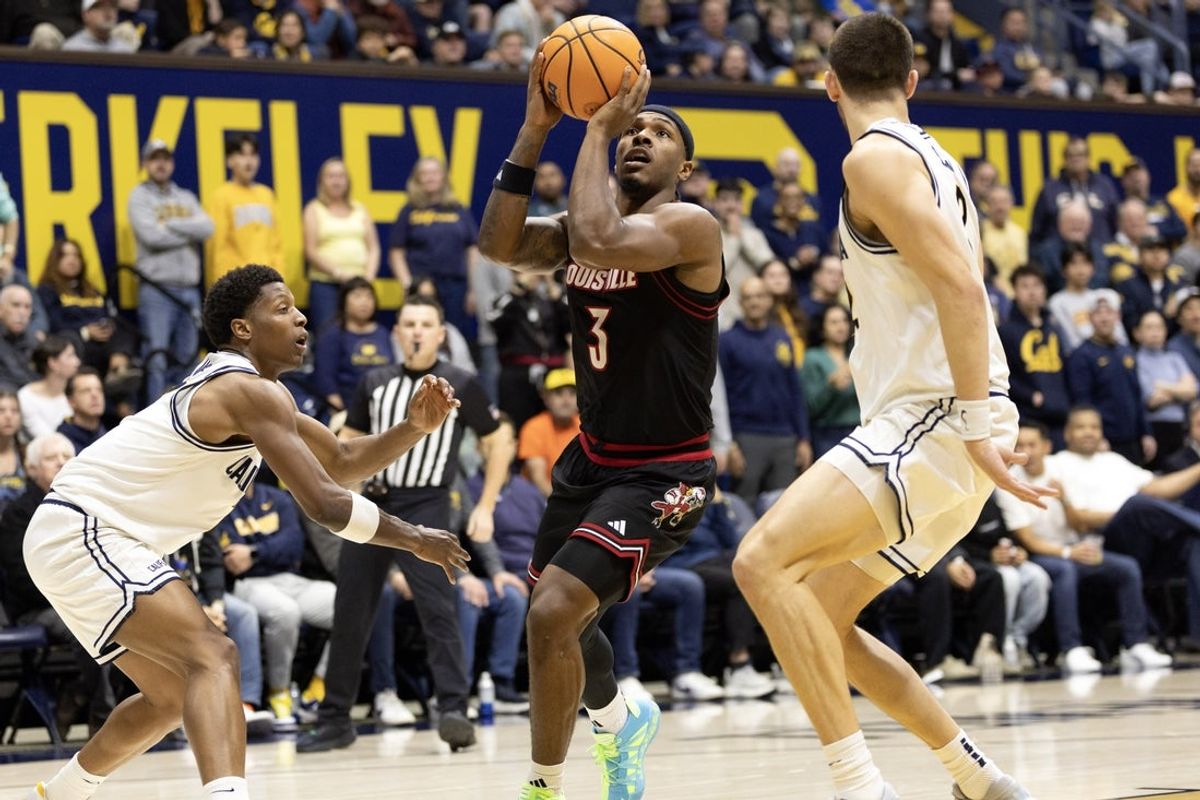 Dec 30, 2025; Berkeley, California, USA; Louisville Cardinals guard Ryan Conwell (3) shoots between California Golden Bears defenders Dai Dai Ames (7) and John Camden (2) during the first half at Haas Pavilion. Mandatory Credit: D. Ross Cameron-Imagn Images