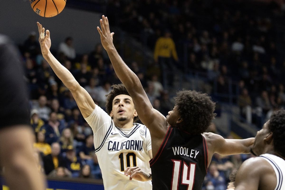 Dec 30, 2025; Berkeley, California, USA; California Golden Bears guard Justin Pippen (10) lays the ball up ahead of Louisville Cardinals guard Adrian Wooley (14) during the second half at Haas Pavilion. Mandatory Credit: D. Ross Cameron-Imagn Images