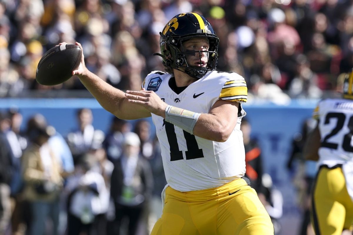Dec 31, 2025; Tampa, FL, USA; Iowa Hawkeyes quarterback Mark Gronowski (11) throws a pass against the Vanderbilt Commodores in the first quarter during the ReliaQuest Bowl at Raymond James Stadium. Mandatory Credit: Nathan Ray Seebeck-Imagn Images