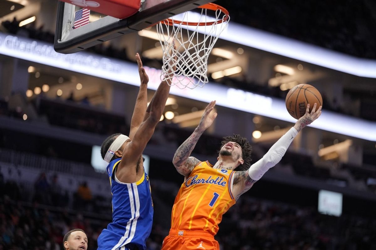 Dec 31, 2025; Charlotte, North Carolina, USA; Charlotte Hornets guard Lamelo Ball (1) drives to the basket against Golden State Warriors guard Gary Payton II (0) during the first quarter at Spectrum Center. Mandatory Credit: Jim Dedmon-Imagn Images
