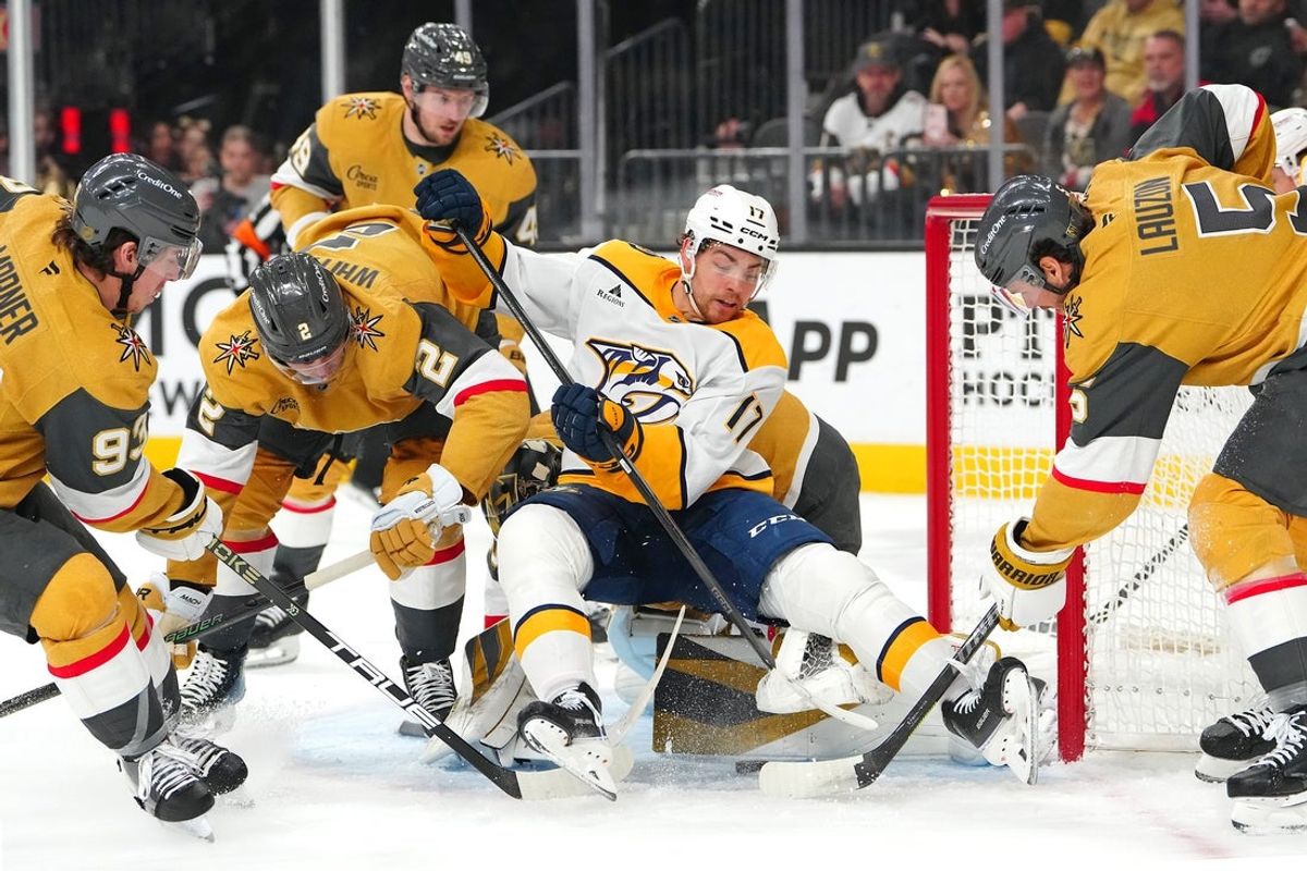 Dec 31, 2025; Las Vegas, Nevada, USA; Nashville Predators center Tyson Jost (17) falls to the ice as Vegas Golden Knights goaltender Akira Schmid (40) covers the puck during the first period at T-Mobile Arena. Mandatory Credit: Stephen R. Sylvanie-Imagn Images