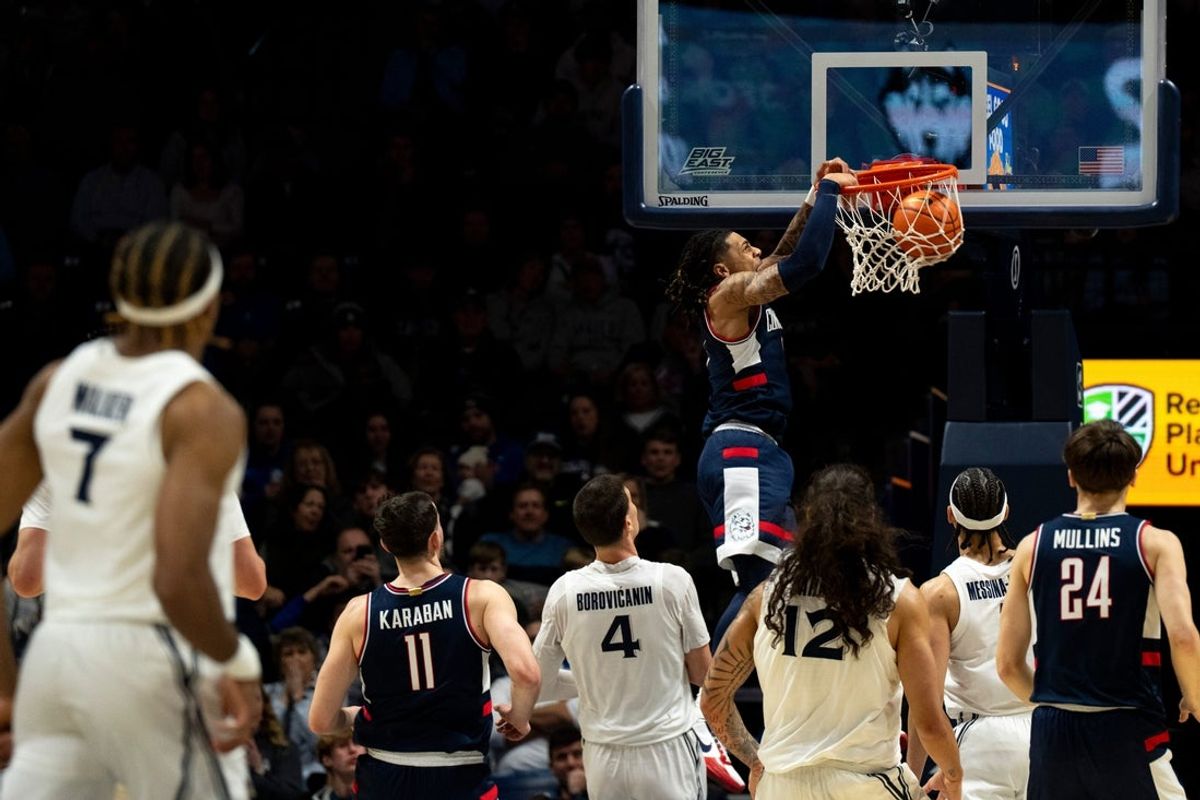 UConn Huskies guard Solo Ball (1) dunks as Xavier Musketeers forward Filip Borovicanin (4) and others look on in the first half of the NCAA basketball game at the Cintas Center in Cincinnati on Dec. 31, 2025.