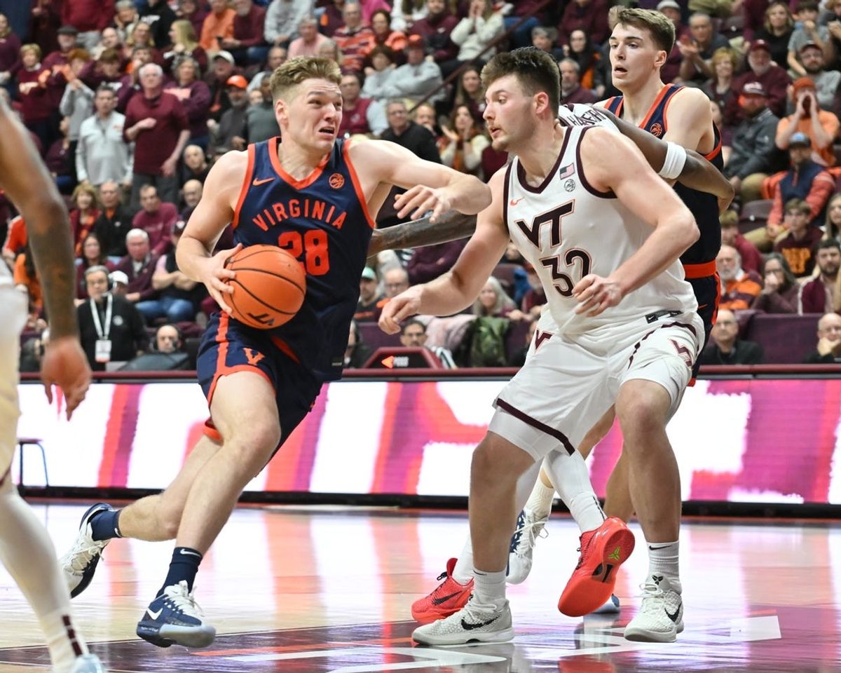 Dec 31, 2025; Blacksburg, Virginia, USA;  Virginia Cavaliers forward Thijs de Ridder (28) drives to the basket as Virginia Tech Hokies center Christian Gurdak (32) defends during the first overtime period  at Cassell Coliseum. Mandatory Credit: Brian Bishop-Imagn Images