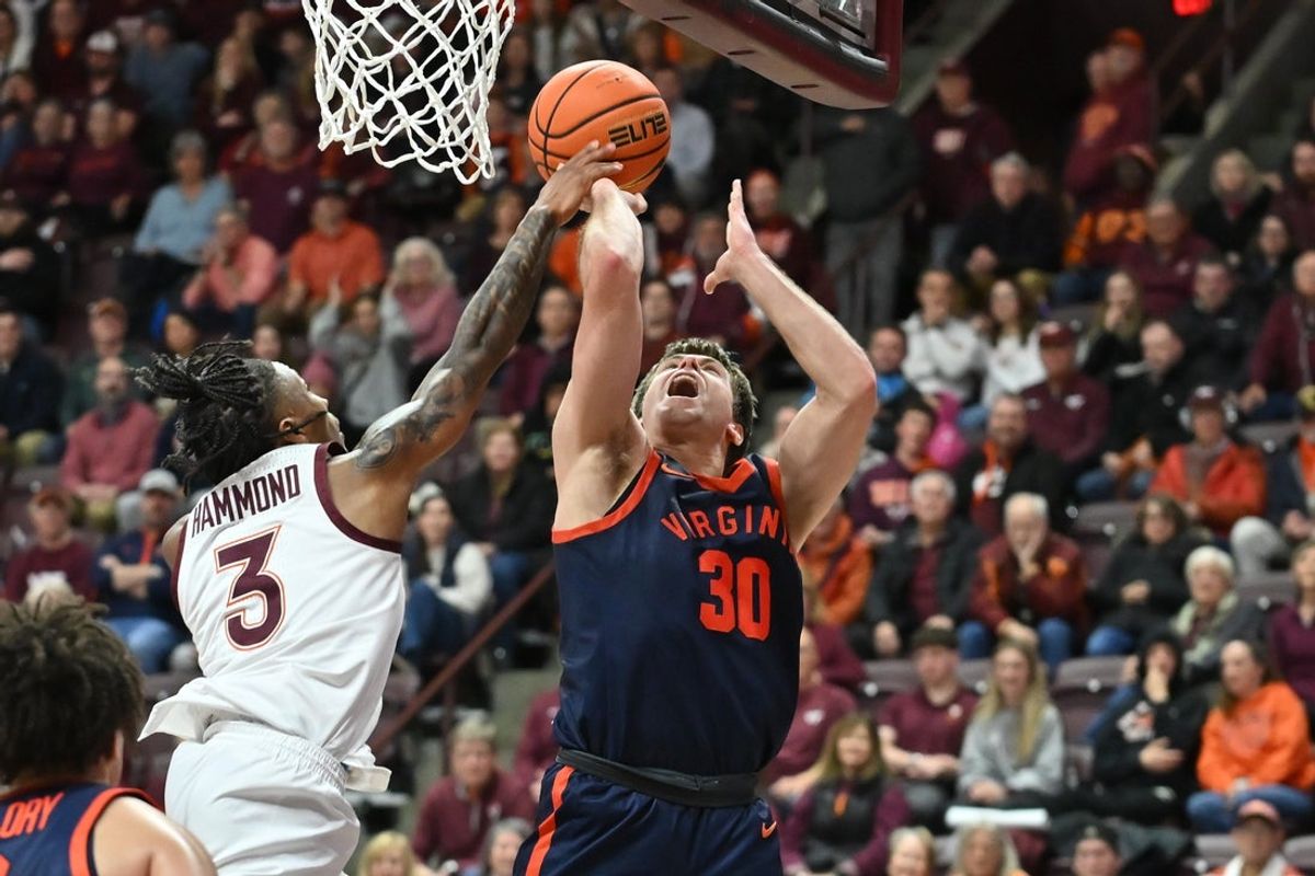 Dec 31, 2025; Blacksburg, Virginia, USA; Virginia Tech Hokies guard Ben Hammond (3) blocks Virginia Cavaliers guard Dallin Hall (30) shot during the second overtime at Cassell Coliseum. Mandatory Credit: Brian Bishop-Imagn Images