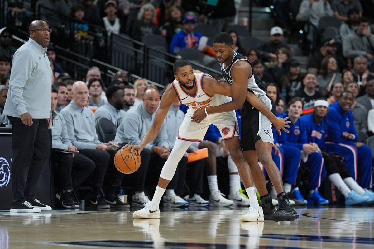 Dec 31, 2025; San Antonio, Texas, USA;  New York Knicks guard Mikal Bridges (25) dribbles against San Antonio Spurs guard De'Aaron Fox (4) in the first half at Frost Bank Center. Mandatory Credit: Daniel Dunn-Imagn Images