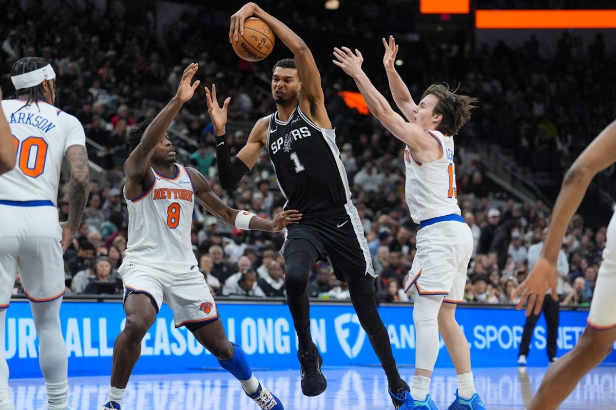 Dec 31, 2025; San Antonio, Texas, USA;  San Antonio Spurs forward Victor Wembanyama (1) dribbles in between New York Knicks forward Og Anunoby (8) and guard Tyler Kolek (13) in the first half at Frost Bank Center. Mandatory Credit: Daniel Dunn-Imagn Images