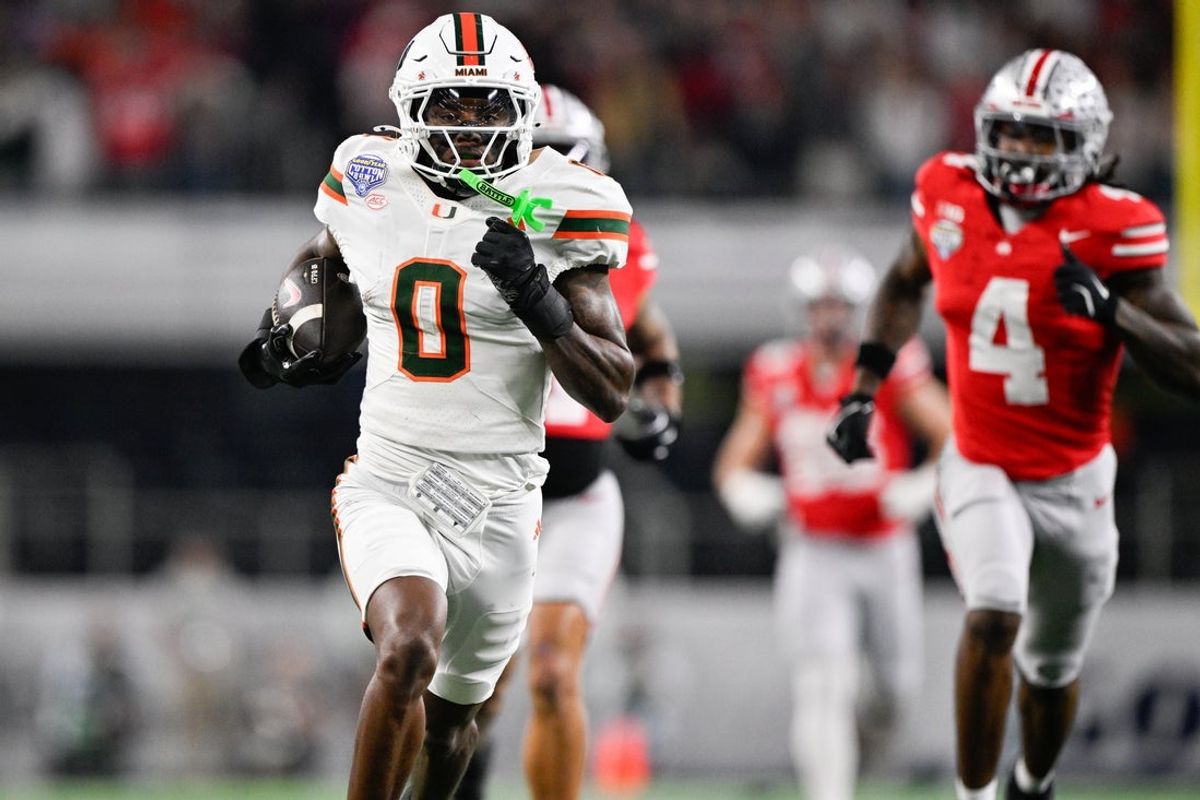 Dec 31, 2025; Arlington, TX, USA; Miami Hurricanes defensive back Keionte Scott (0) runs the ball for a touchdown after an interception against the Ohio State Buckeyes in the second quarter during the 2025 Cotton Bowl and quarterfinal game of the College Football Playoff at AT&T Stadium. Mandatory Credit: Jerome Miron-Imagn Images